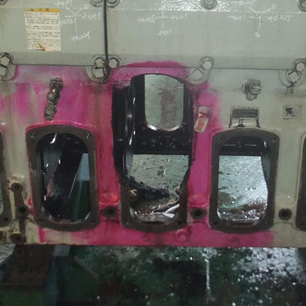 Close up of damaged crank case door caused by connecting rod failure prior to metallock repair by Goltens