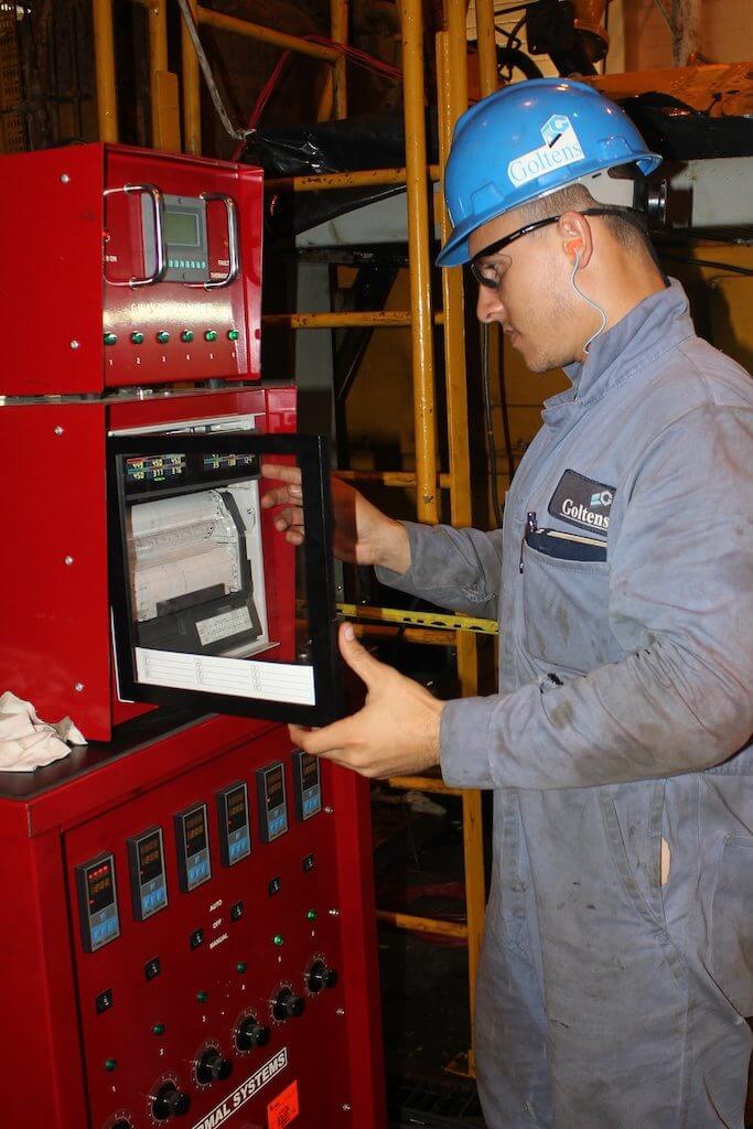 Goltens Service Engineer adjusting settings on annealing equipment