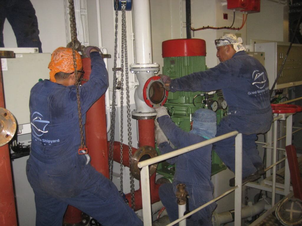 Shipyard workers installing piping prefabricated by Goltens