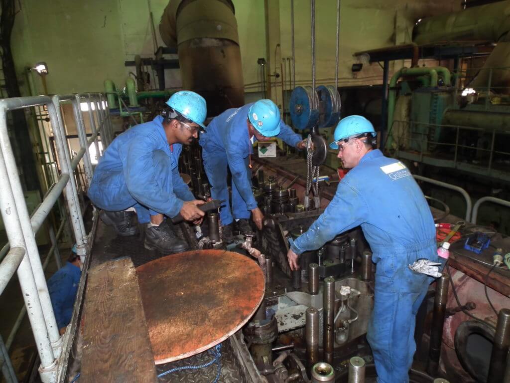 Goltens’ Diesel Technicians fastening the lifting yoke to remove a cylinder head from the engine